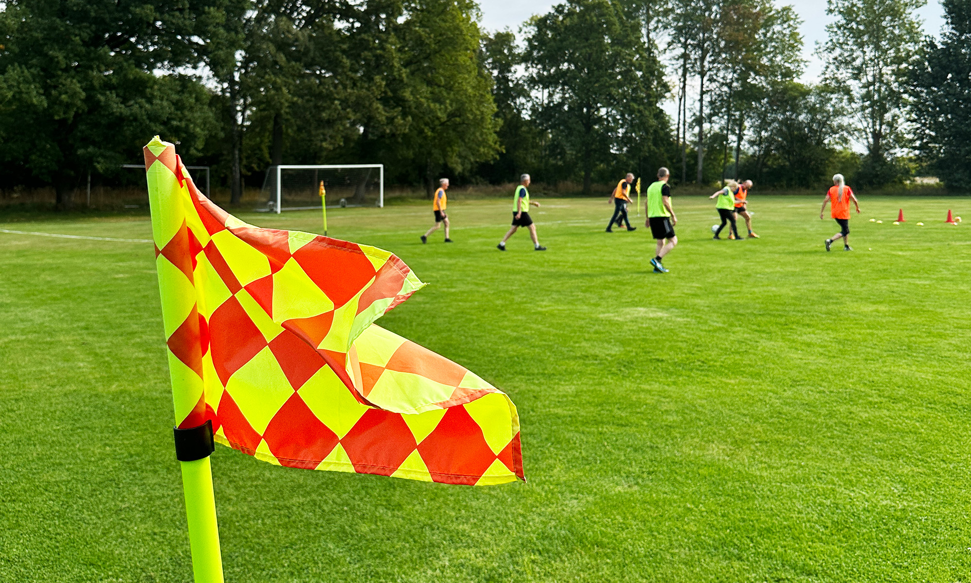 Footballflag in front of footballplayers playing football.