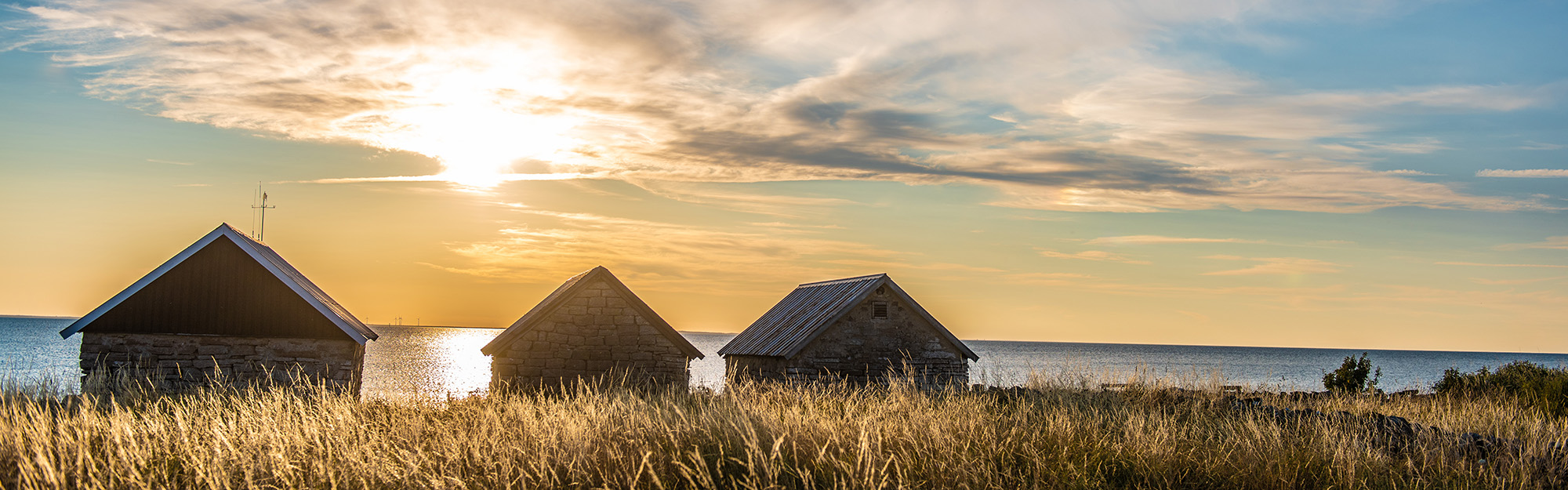 Three boathouses at sunset